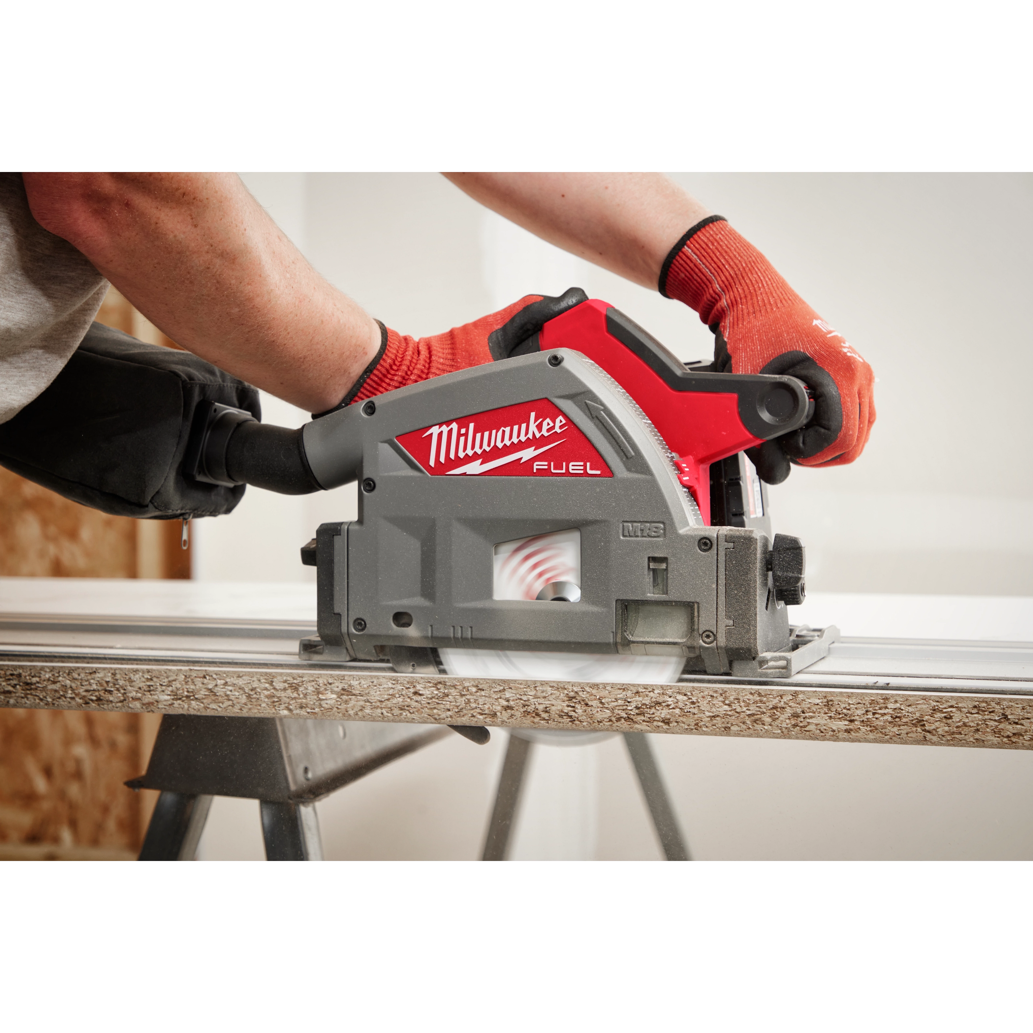 Person using a 6-1/2" 52T Laminate Track Saw BLD to cut a piece of wood, showing the tool's close-up while in action.