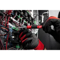 Gloved hands using a 14-in-1 Precision Multi-Bit Screwdriver to adjust wiring in an electrical panel filled with colorful wires.