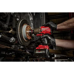 Mechanic using SHOCKWAVE Impact Duty 3/4" Drive 36MM Deep 6 Point Socket attached to a red power drill on a vehicle's brake rotor.