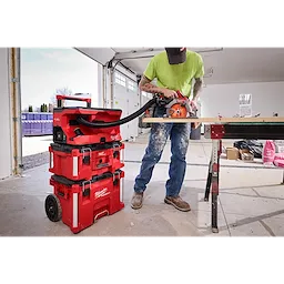 Worker cutting wood with saw connected to M18 FUEL 4 Gallon Wet/Dry Vacuum w/ PACKOUT Compatibility & VACLINK..
