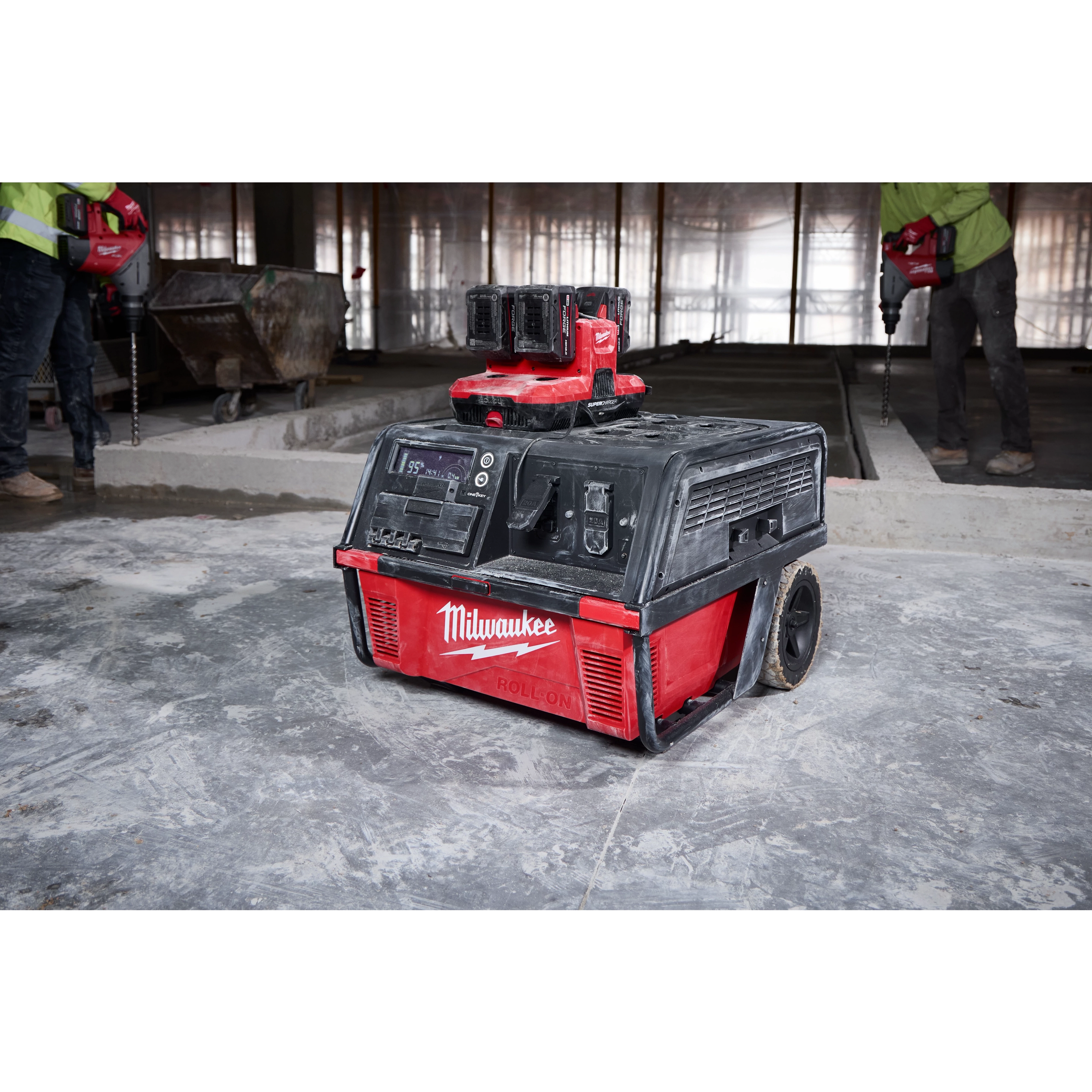 Milwaukee ROLL-ON 7200W/3600W 6.0kWh Power Supply unit on wheels, placed at a construction site with workers in the background.