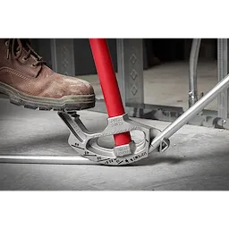 1/2" EMT Aluminum Conduit Bender with red handle being used by a person wearing a work boot to bend a metal conduit pipe.