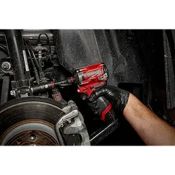 A gloved hand uses a red impact wrench to tighten a bolt on a car part with the SHOCKWAVE Impact Duty 3/8" Drive 16MM Deep 6 Point Socket.
