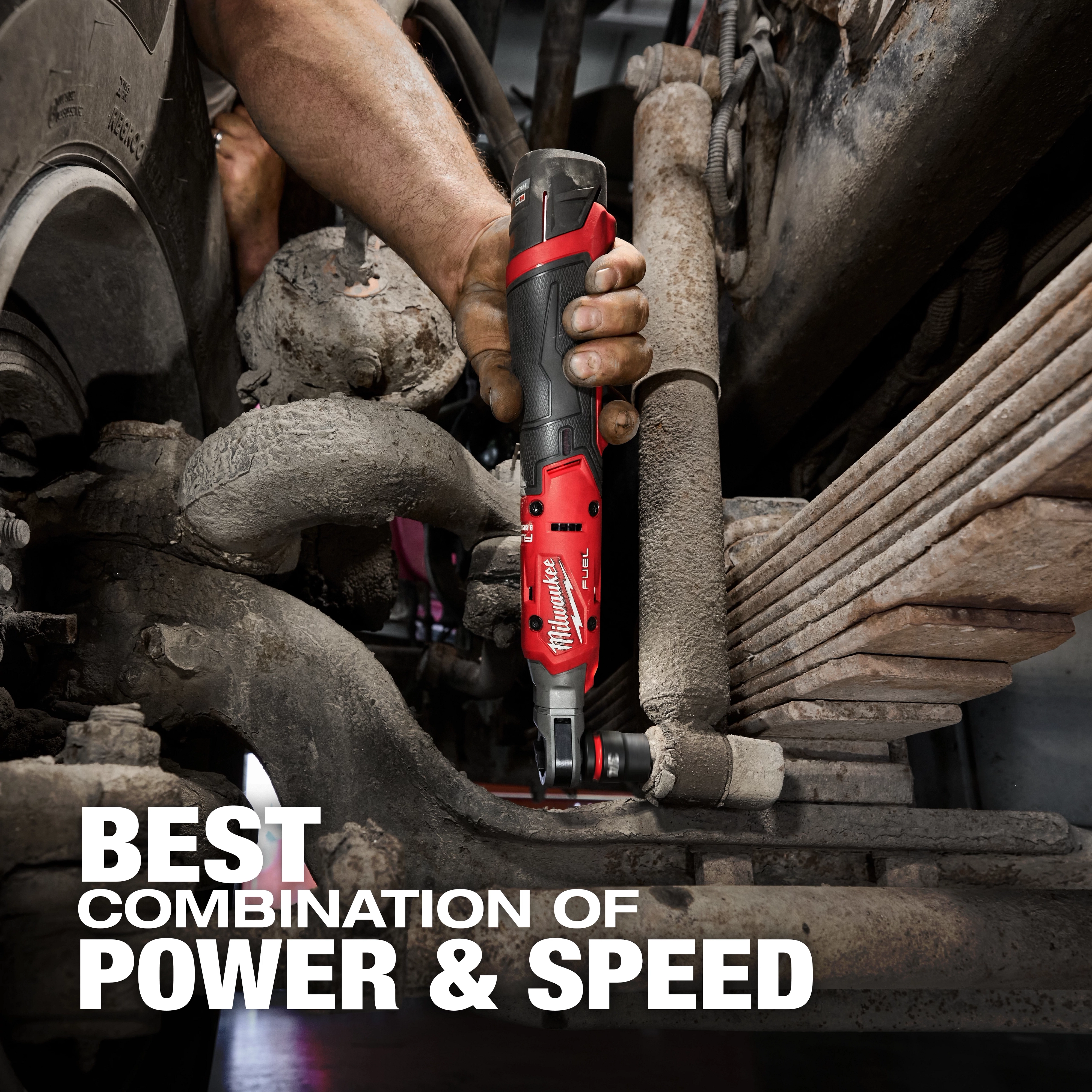 A person uses the M12™ FUEL™ 1/2" Ratchet to work on automotive machinery. The ratchet is black and red, with the text "Best Combination of Power & Speed" displayed in the lower left corner.
