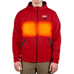 The M12™ Heated Hoodie is a red, zip-up garment with heating elements around the chest area, highlighted by a glowing orange effect. It features black pockets and a hood. The Milwaukee logo is visible on the left chest. The hoodie is being worn by a person, emphasizing its fit and functionality.