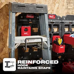 The image features a PACKOUT Wide Hook holding a ladder on a workshop wall with multiple PACKOUT storage units nearby, showing reinforced hook support.