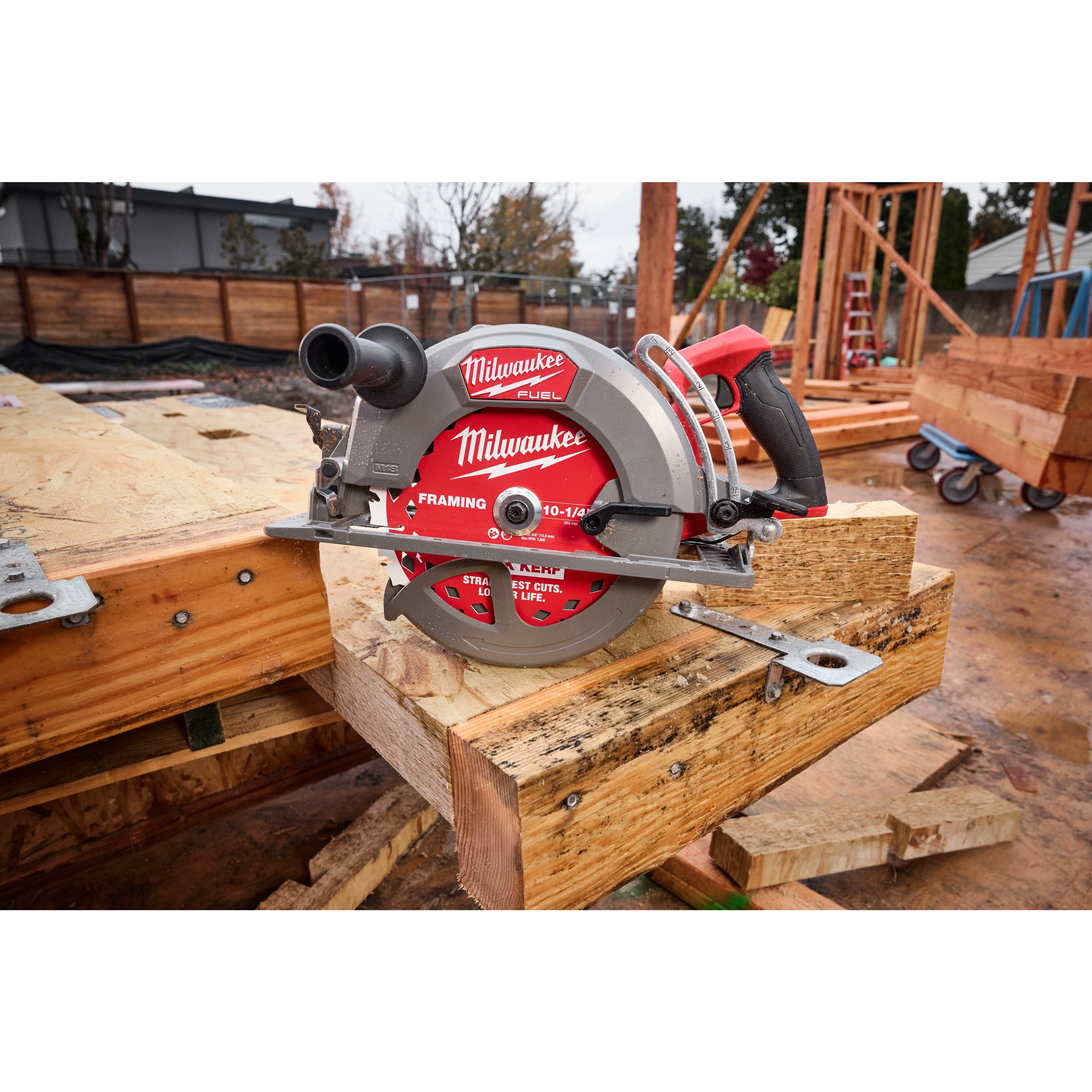 The M18 FUEL 10-1/4" Rear Handle Circular Saw is placed on a construction site workbench, surrounded by timber and tools.