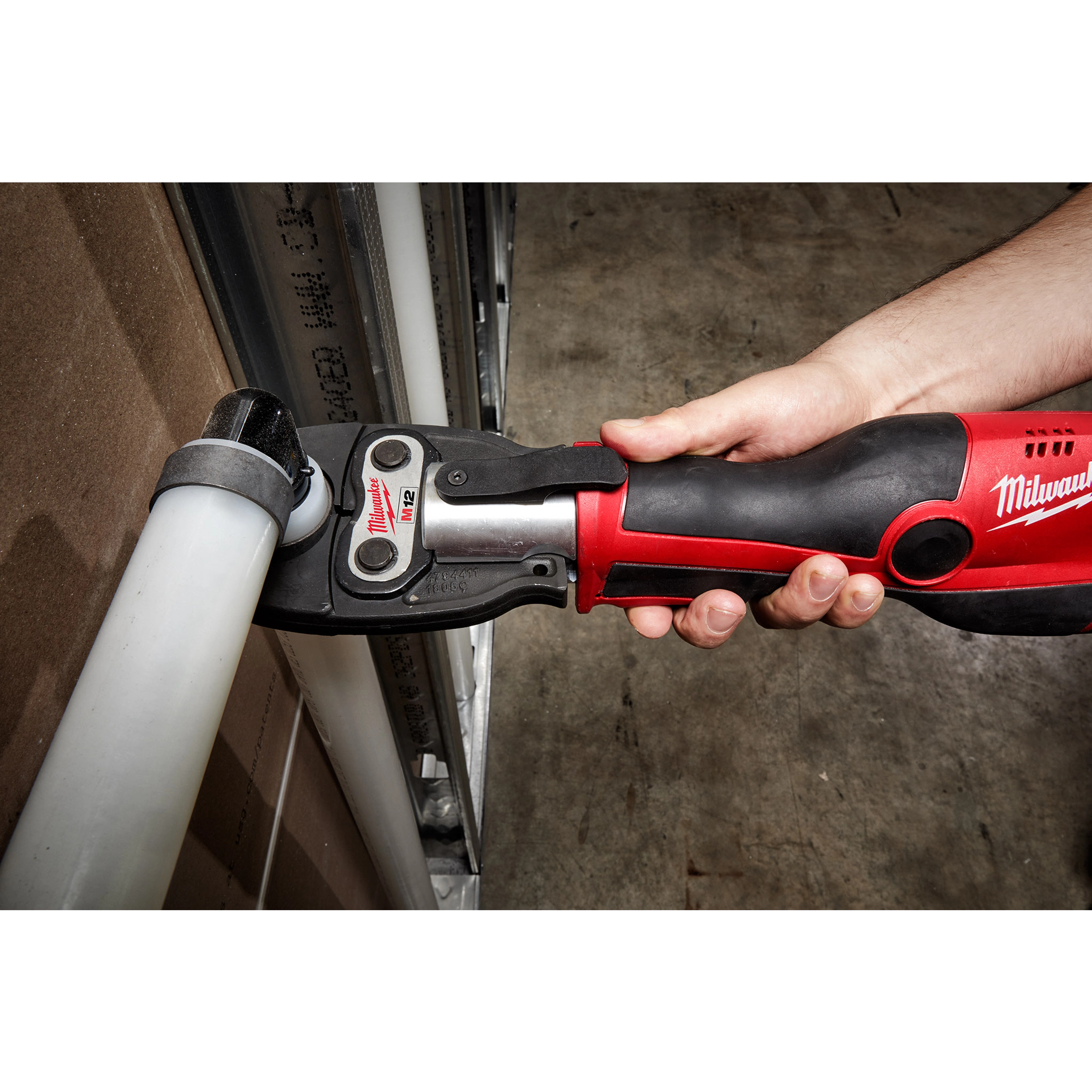A 1/2" PEX Crimp Jaw for M18 FORCE LOGIC Press Tool is being used to crimp tubing in a workshop setting.