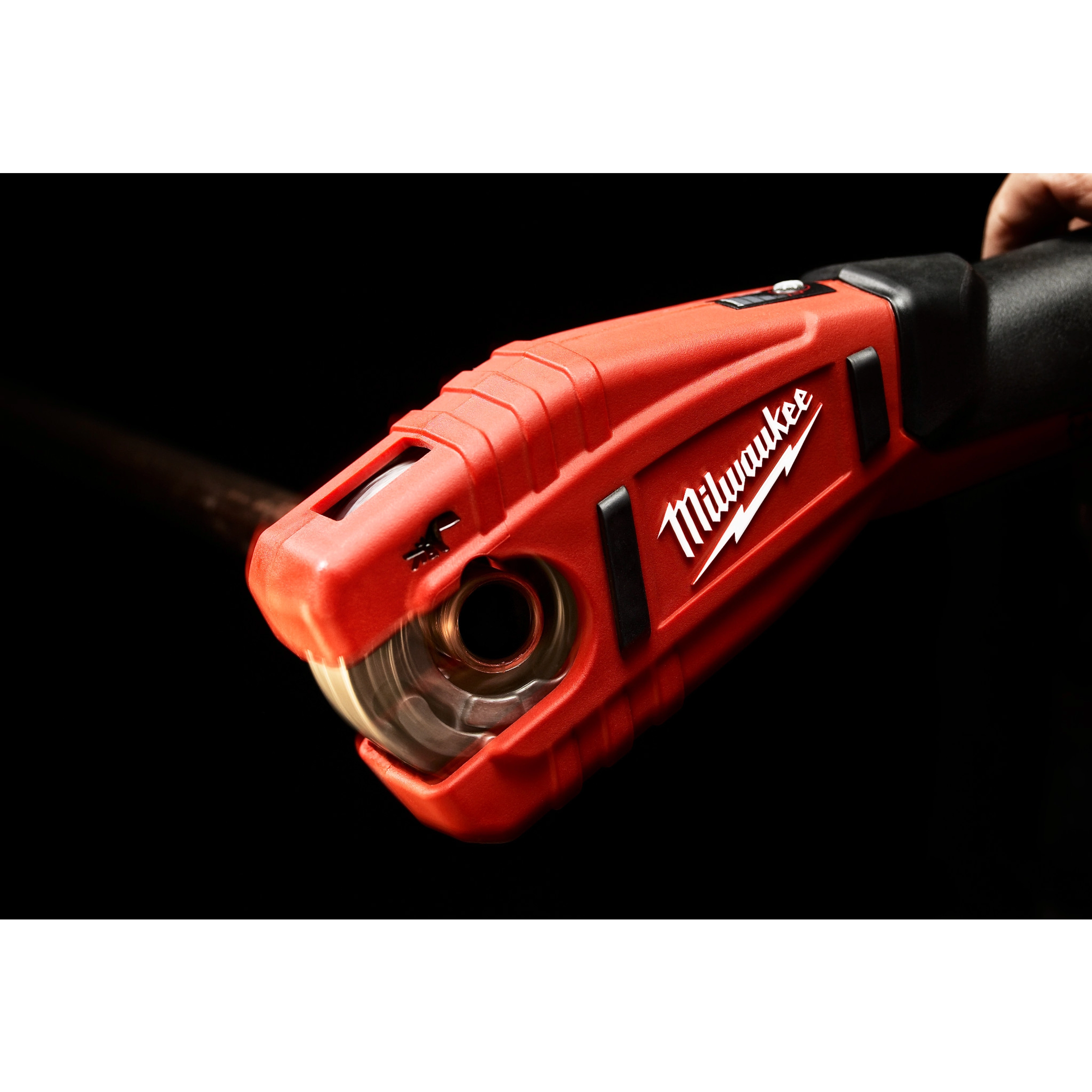 Red Milwaukee M12 Copper Tubing Cutter, 2471 in use, cutting a copper pipe with its precision blade. Product held by black handle.