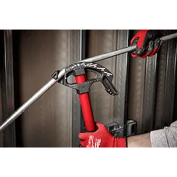 1/2" EMT Iron Conduit Bender with red handle, used by a person wearing red work gloves to bend conduit pipe in a construction setting.