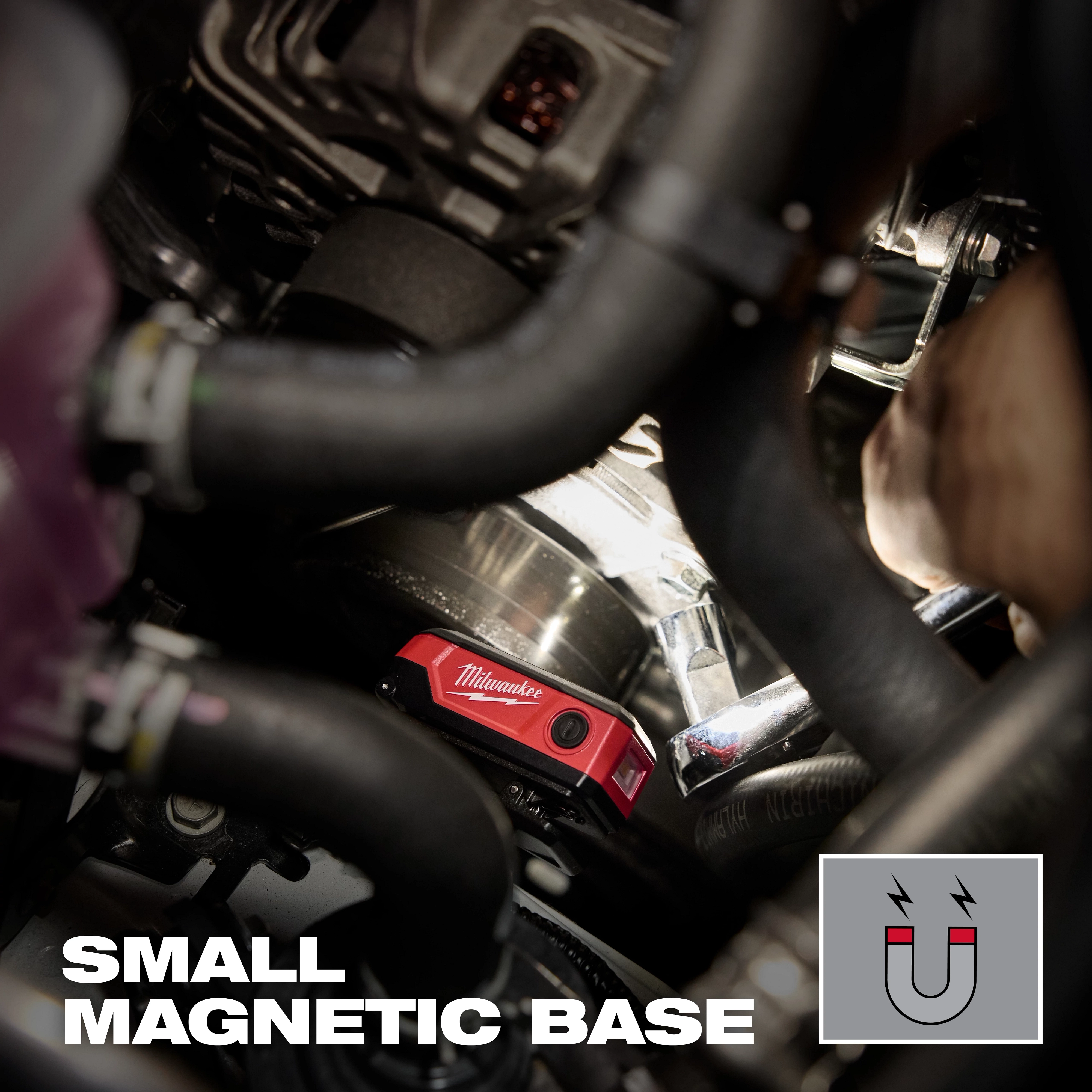 Milwaukee magnetic level with small magnetic base attached inside a crowded engine bay.