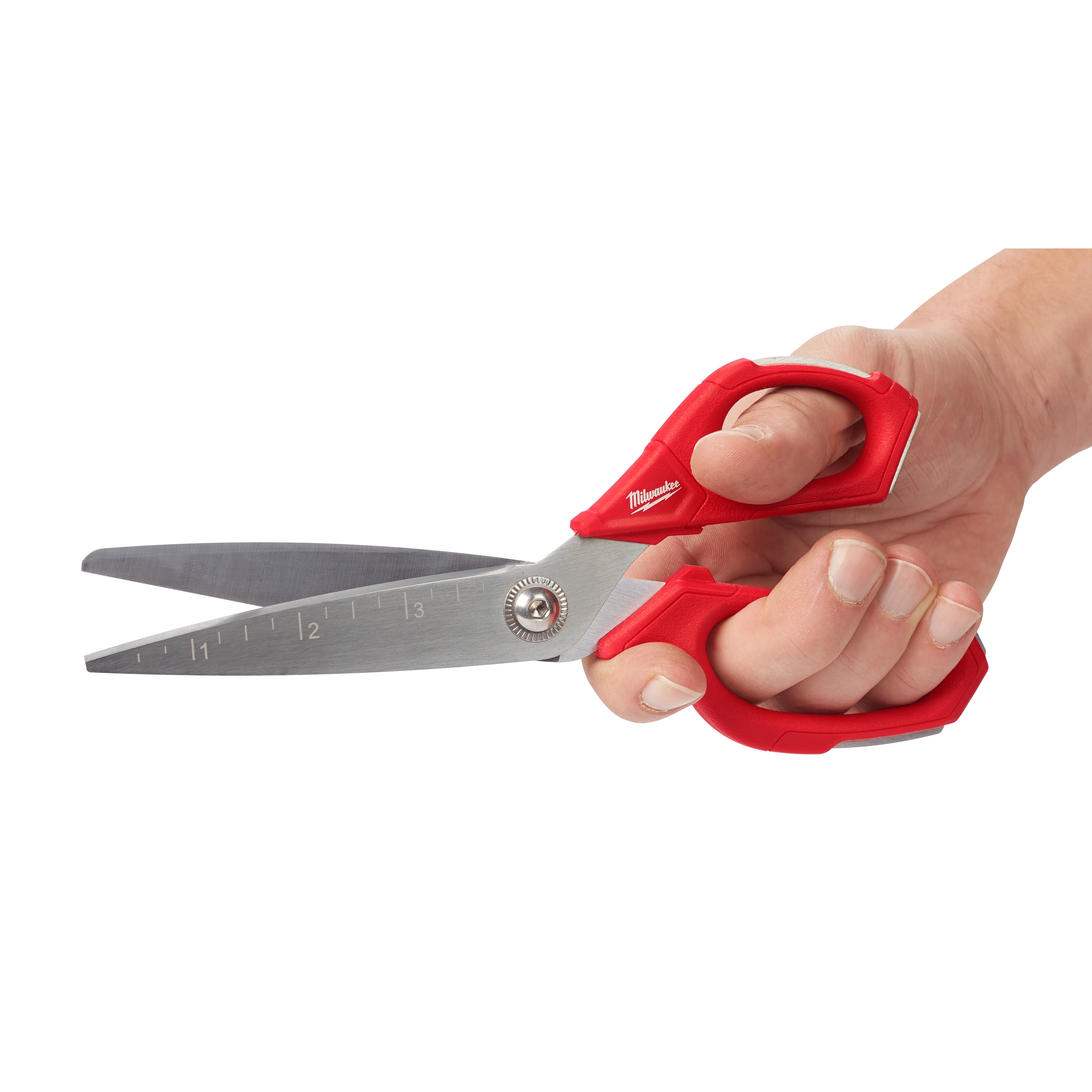 A hand holding Offset Jobsite Scissors with red ergonomic handles. The scissor blades are stainless steel and feature measurement markings in inches, with a pivot joint for smooth operation. The brand name is visible on the handles.
