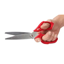 A hand holding Offset Jobsite Scissors with red ergonomic handles. The scissor blades are stainless steel and feature measurement markings in inches, with a pivot joint for smooth operation. The brand name is visible on the handles.
