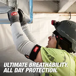 Worker wearing Milwaukee Cut Level 4 Protective Sleeves - 16" while installing overhead ductwork indoors.