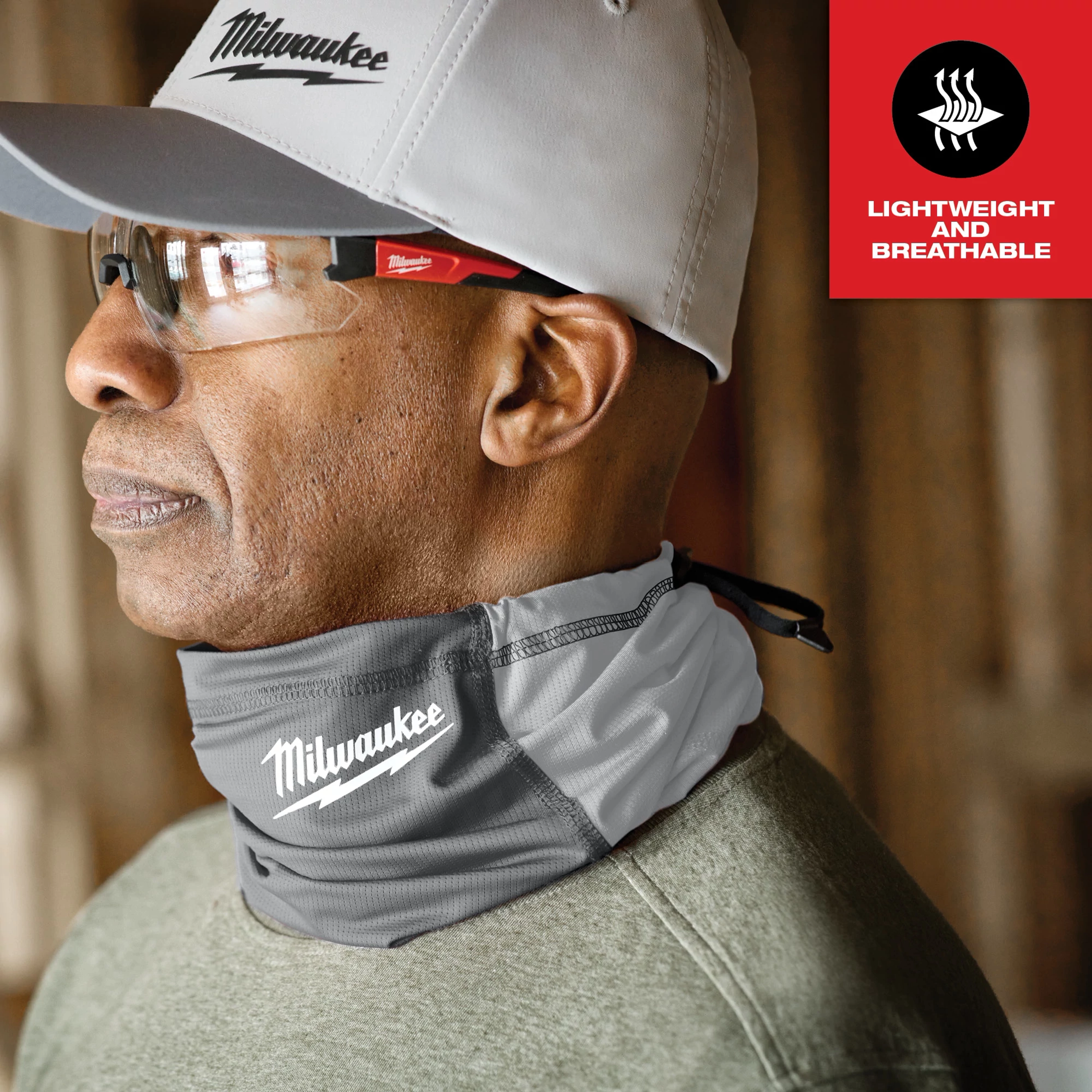Person wearing a gray WORKSKIN Performance Neck Gaiter with white stitching and a logo, advertised as lightweight and breathable.