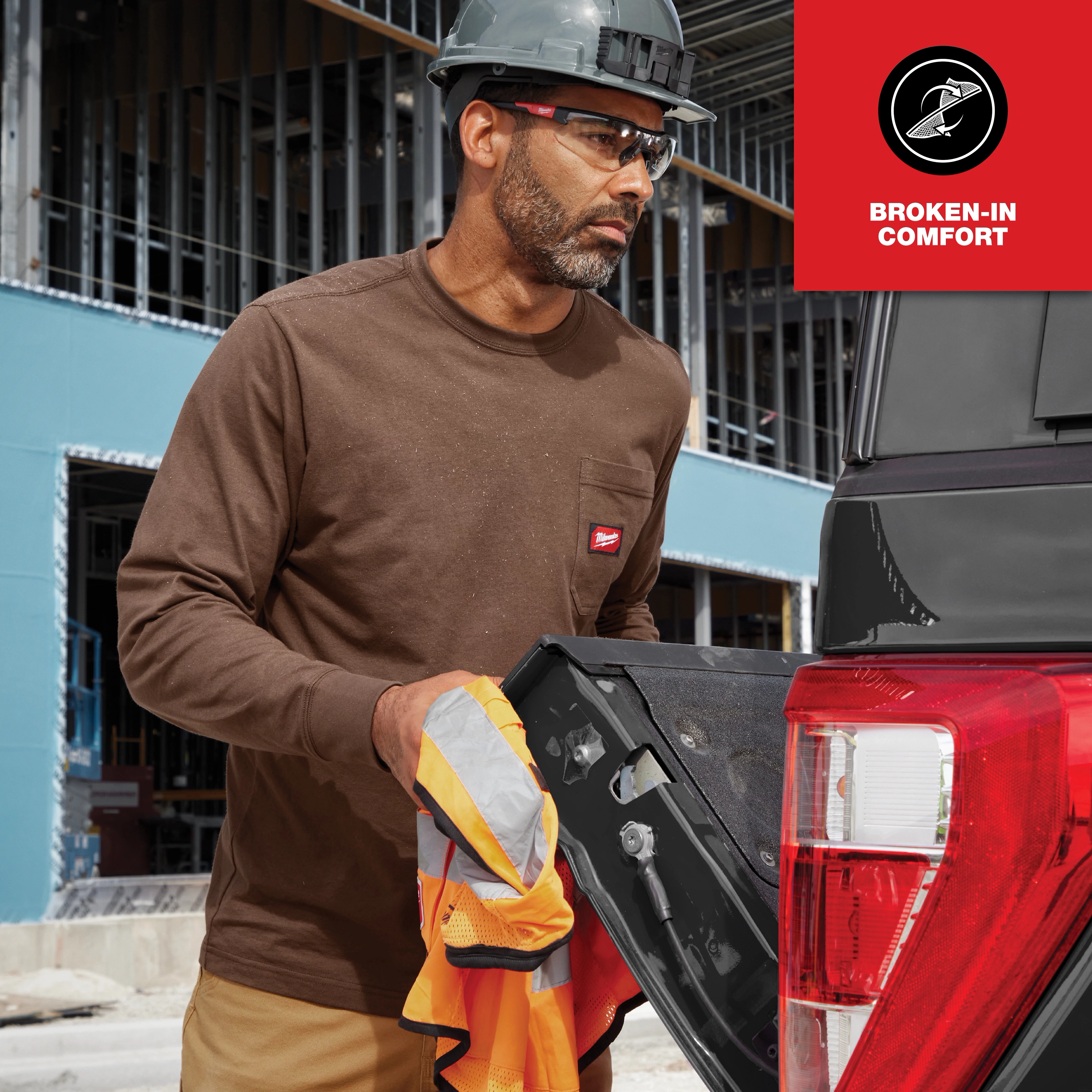Man wearing the GRIDIRON Pocket Long Sleeve T-Shirt, working at a construction site with a truck in the background.