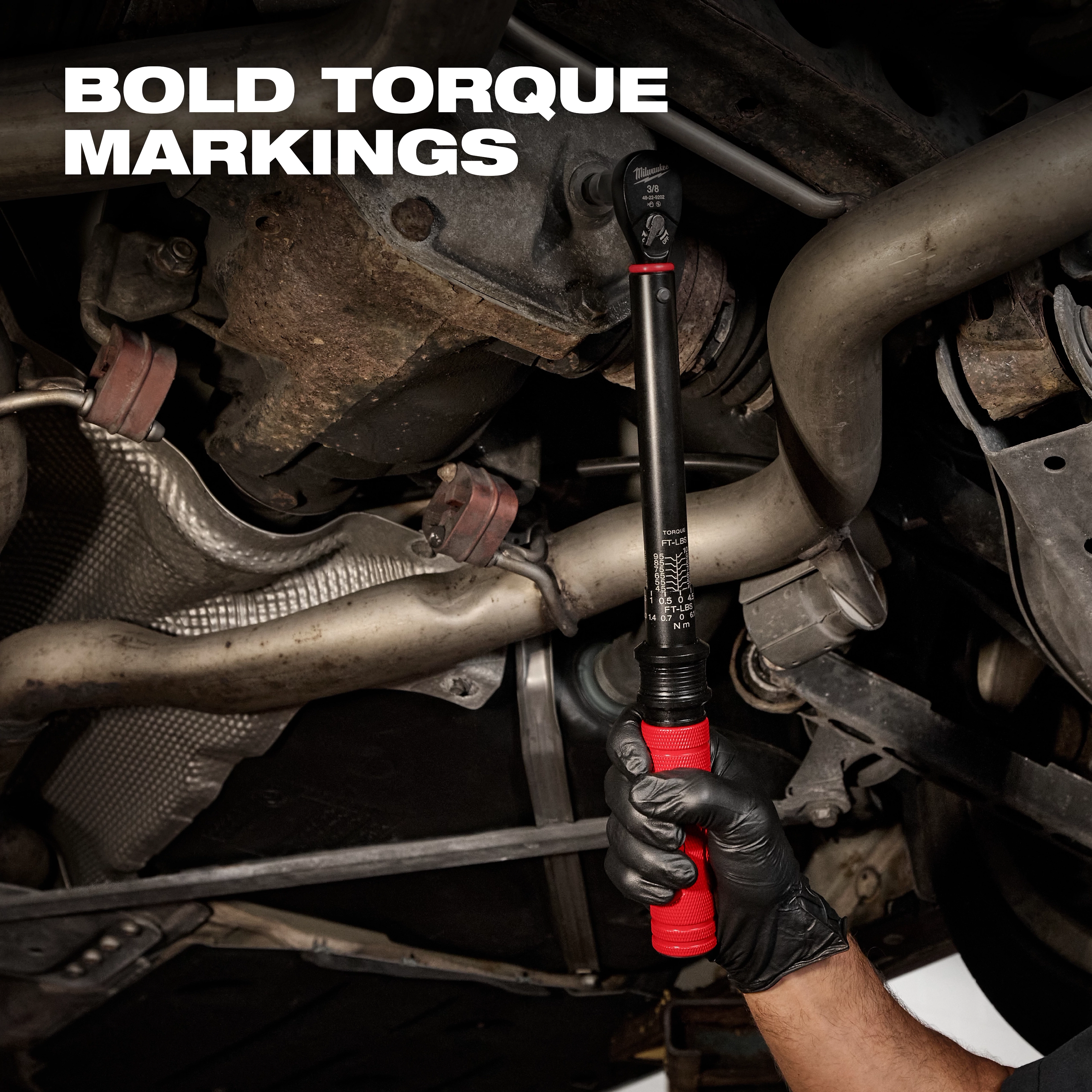 3/8” Drive Click Torque Wrench (20-100 ft·lbf) held by a gloved hand, tightening a bolt under a vehicle with bold torque markings visible.