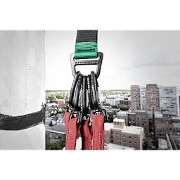 50LBS Anchor Strap with multiple carabiners attached to red straps, hanging from a high-rise building, cityscape in the background.