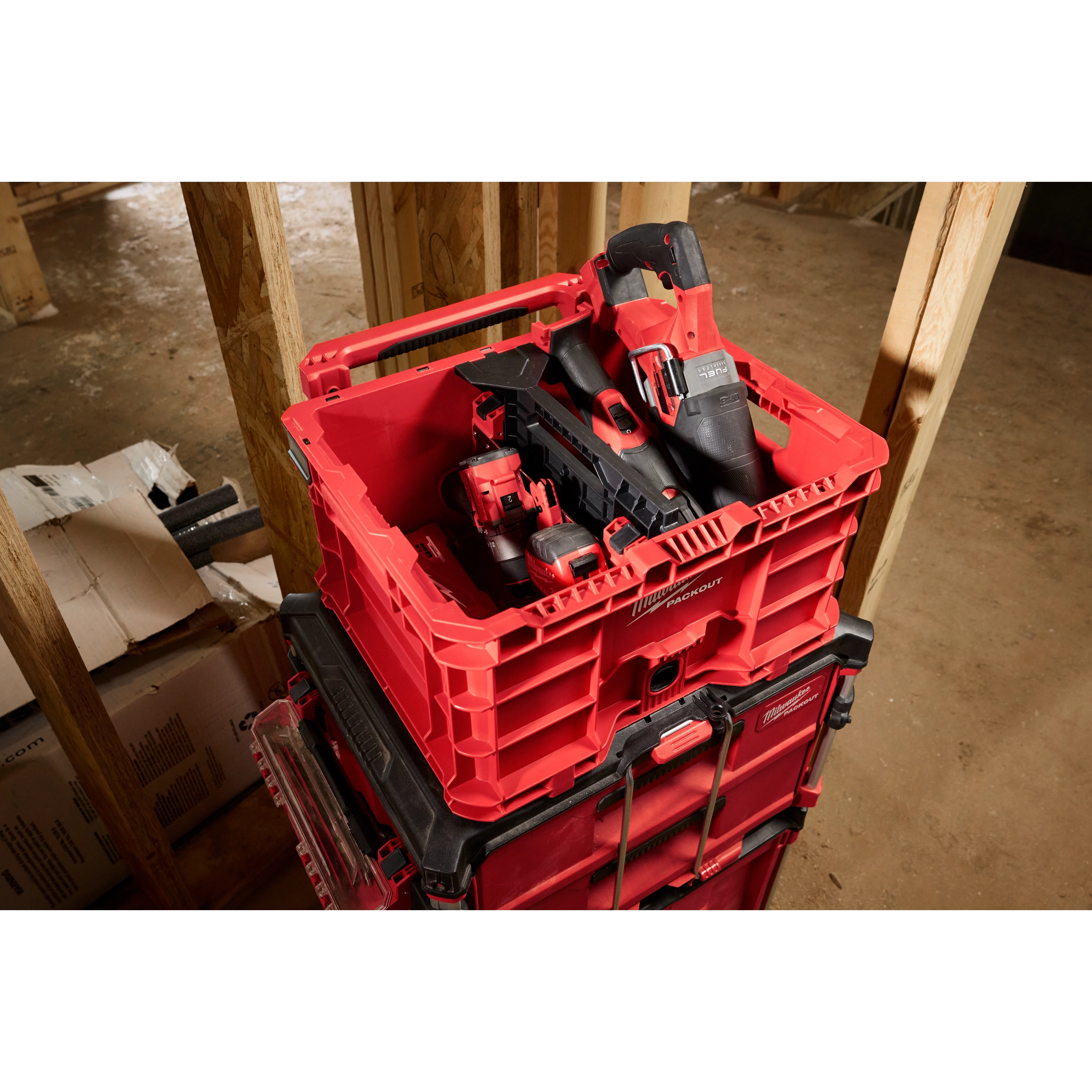Red Divider for PACKOUT Crate containing power tools, stacked on top of other PACKOUT storage units in a construction site.