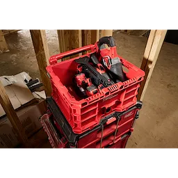 Red Divider for PACKOUT Crate containing power tools, stacked on top of other PACKOUT storage units in a construction site.