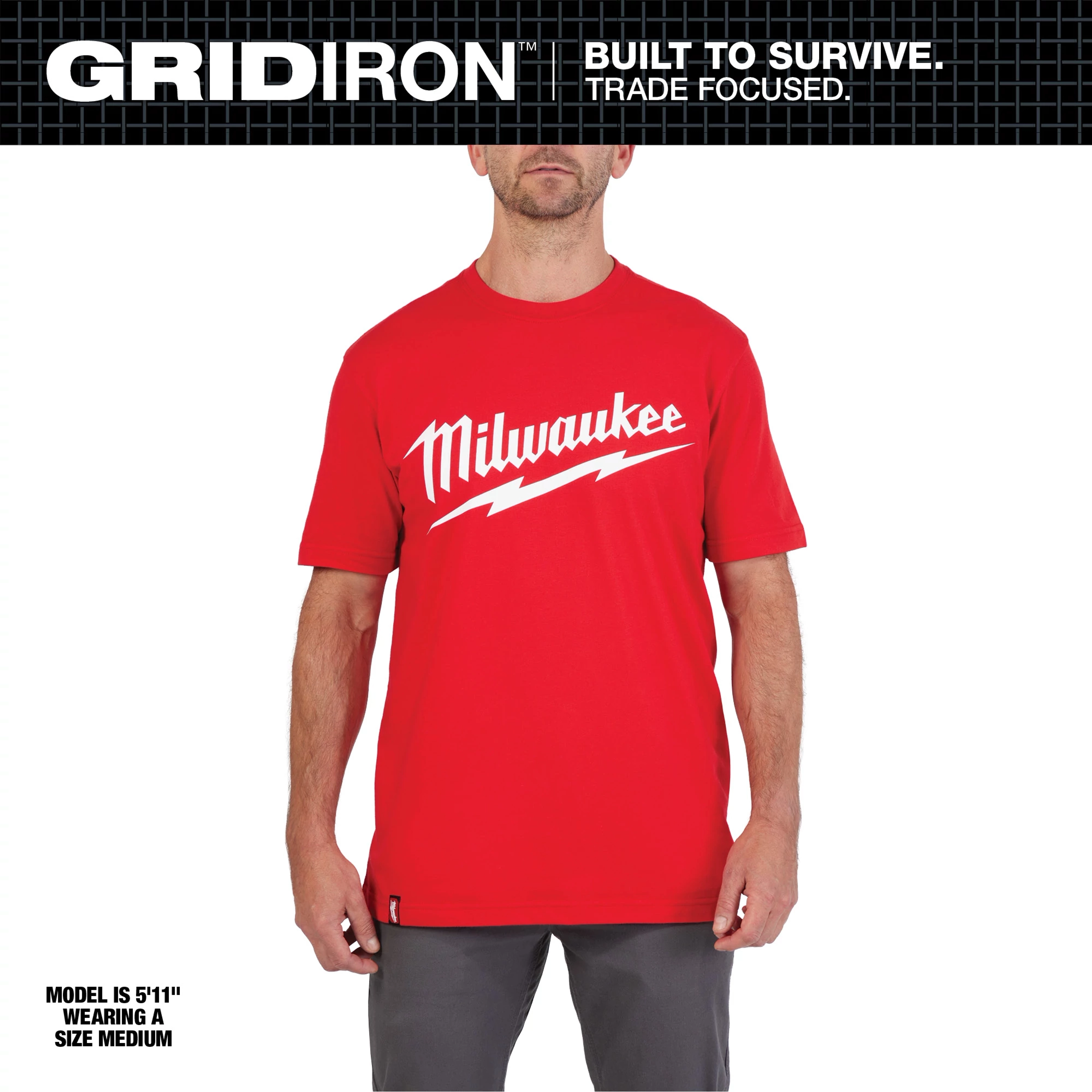 Heavy Duty Tee Primary Image: A model wearing a red t-shirt with white Milwaukee logo and lightning bolt design, size medium.