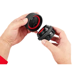 A person holds the PACKOUT Sip Lid, showing the removable cap with a sealing ring and the threaded portion.