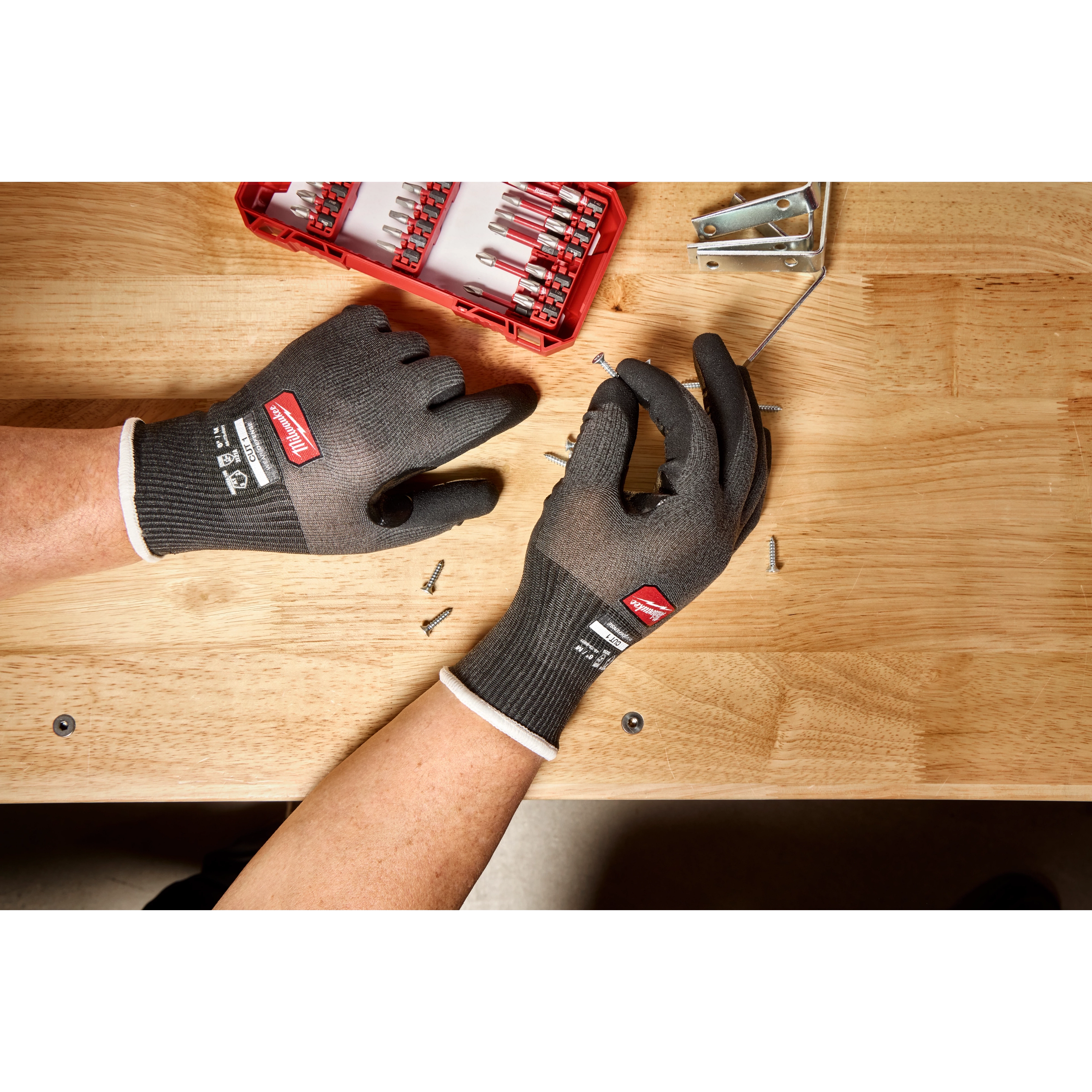 Cut Level 1 Nitrile Dipped Gloves w/ WEAR-DEFENSE Protection handling screws on a wooden workbench.
