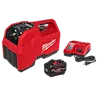 The image features the Milwaukee M18 Brushless Refrigerant Recovery Machine, a red, portable device. It comes with a rechargeable battery pack and a charger, both displayed next to the machine. The machine has multiple control knobs and hose connectors on the front panel.