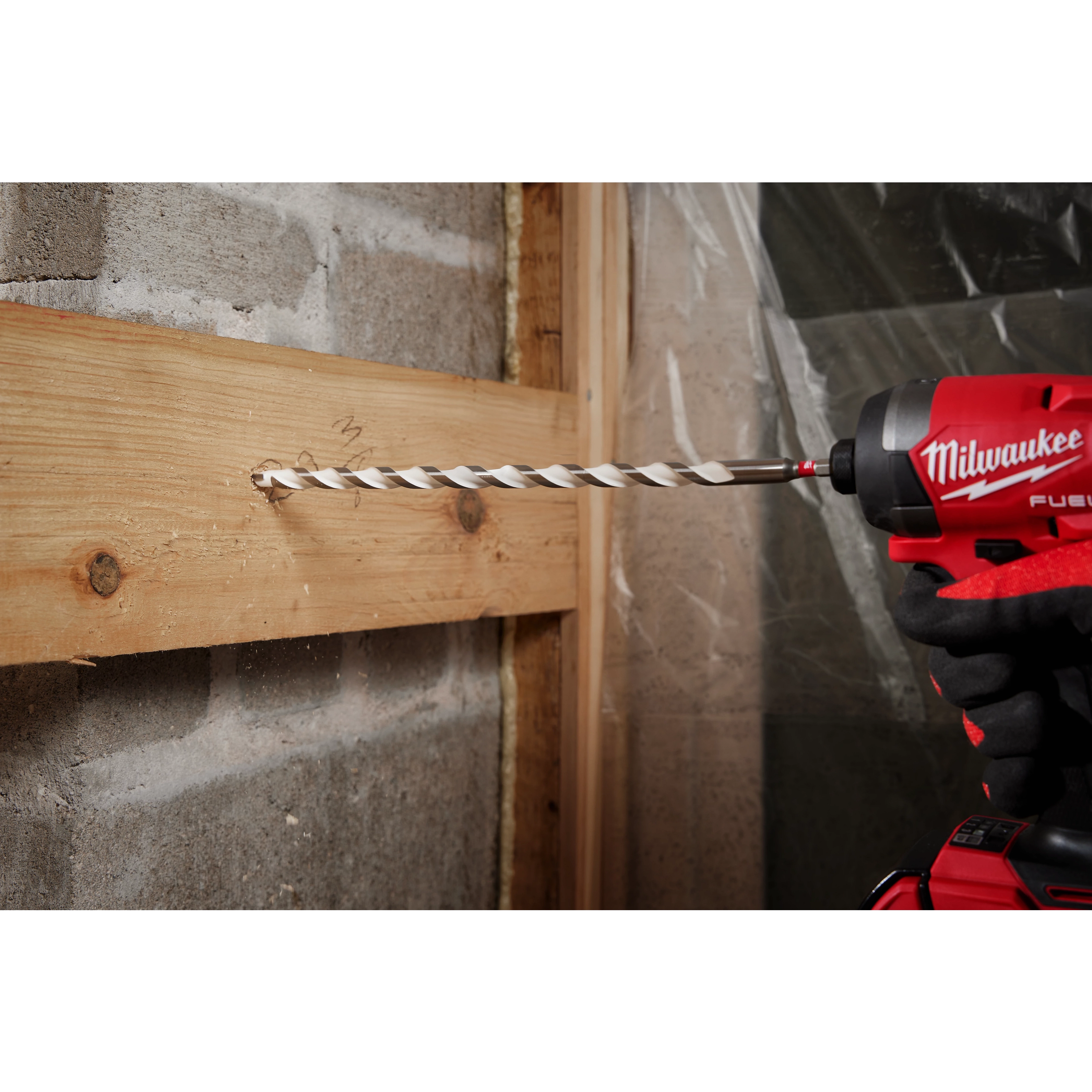 A 1/2" x 10" x 12" SHOCKWAVE Impact Duty Carbide Multi-Material Drill Bit being used to drill through a wooden board.