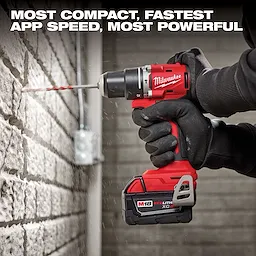 A person uses a power drill from the M18 4-Tool Combo Kit to drill into a brick wall. The drill has a red and black design with a visible battery pack labeled "REDLITHIUM XC4.0." The text above highlights the drill’s compact, fast, and powerful performance.