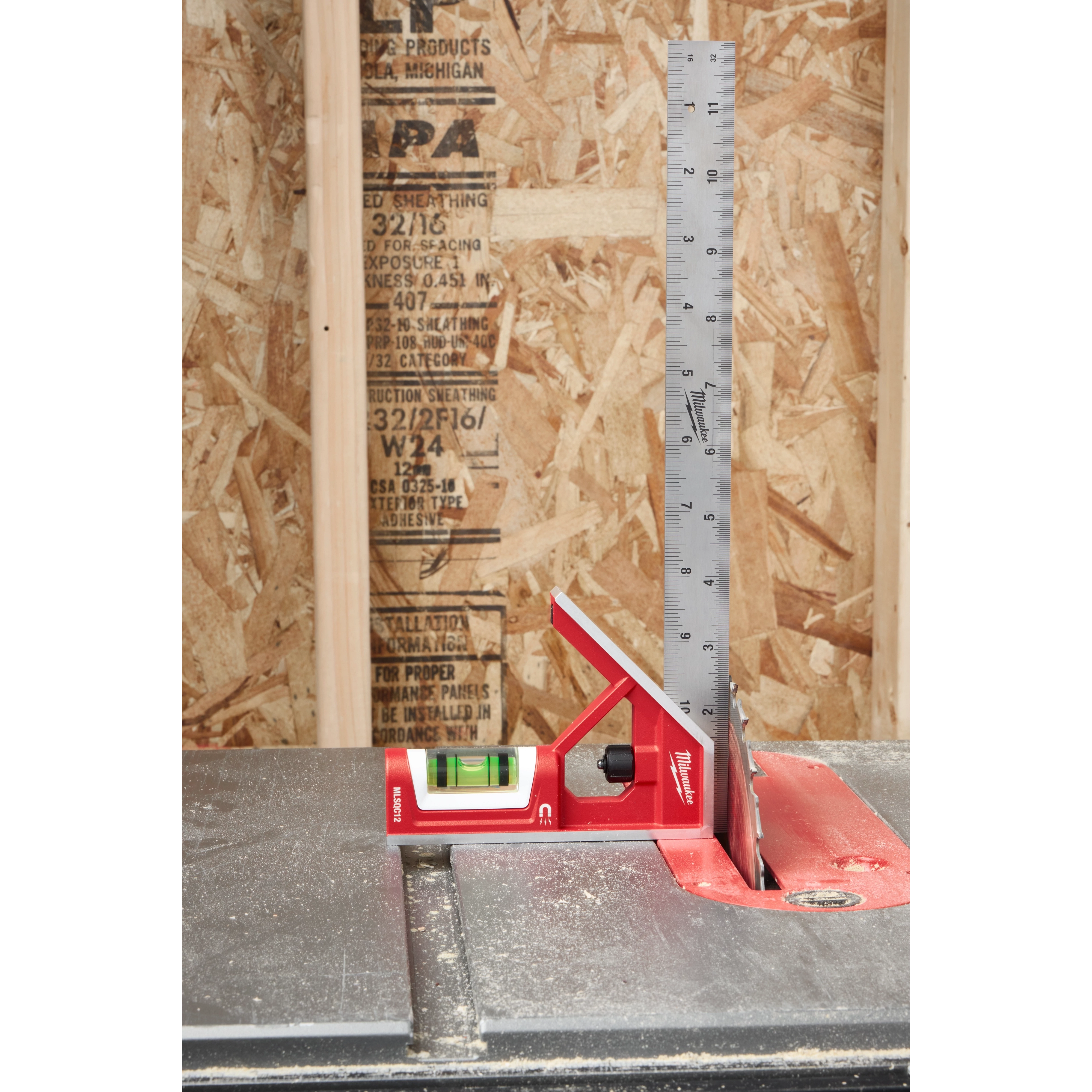 12" Magnetic Combination Square with red body and silver ruler, measuring blade angle on table saw against wooden background.