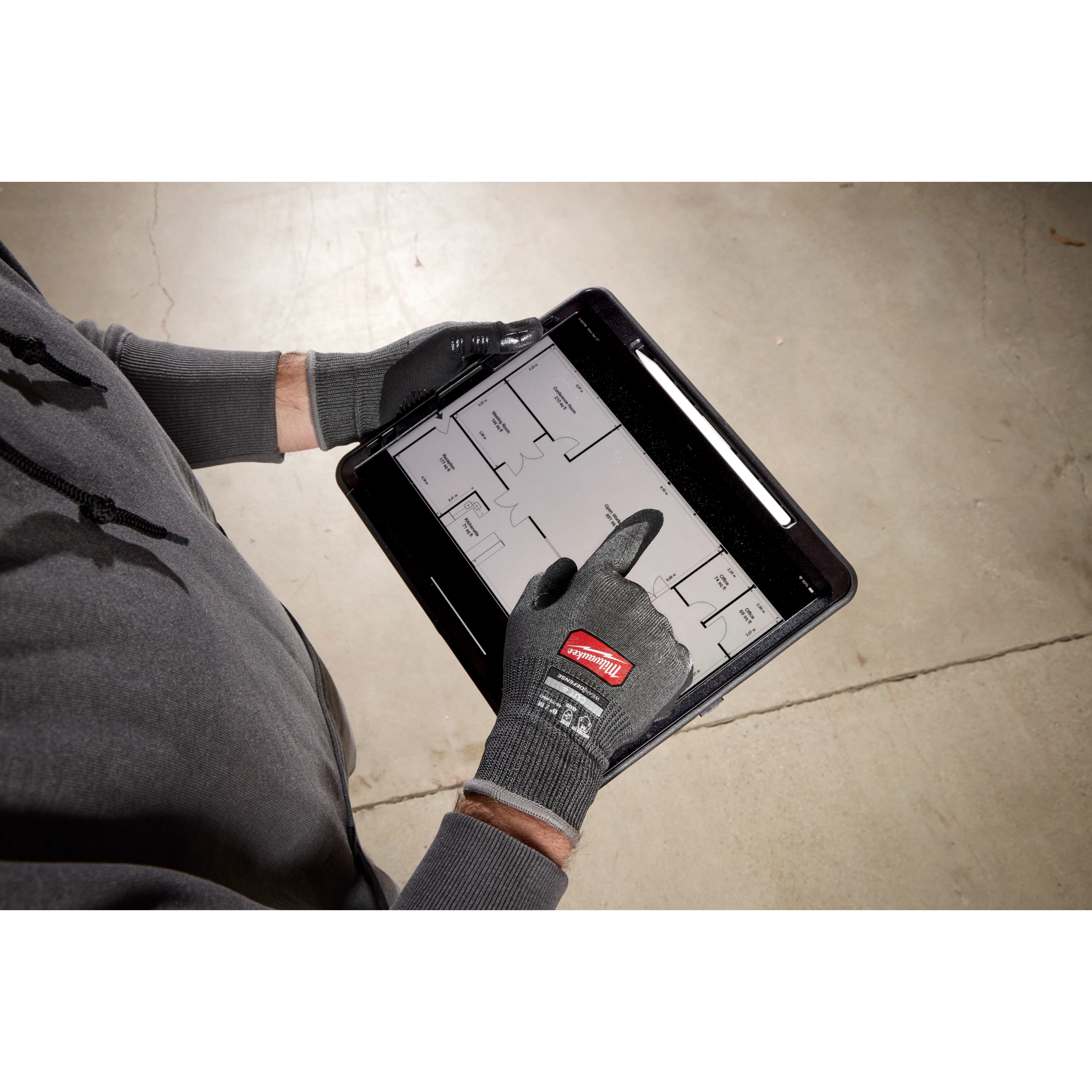 Hands wearing Cut Level 4 High Dexterity Nitrile Dipped Gloves w/ WEAR-DEFENSE Protection using a tablet with a floor plan.