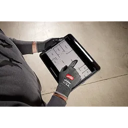Hands wearing Cut Level 4 High Dexterity Nitrile Dipped Gloves w/ WEAR-DEFENSE Protection using a tablet with a floor plan.