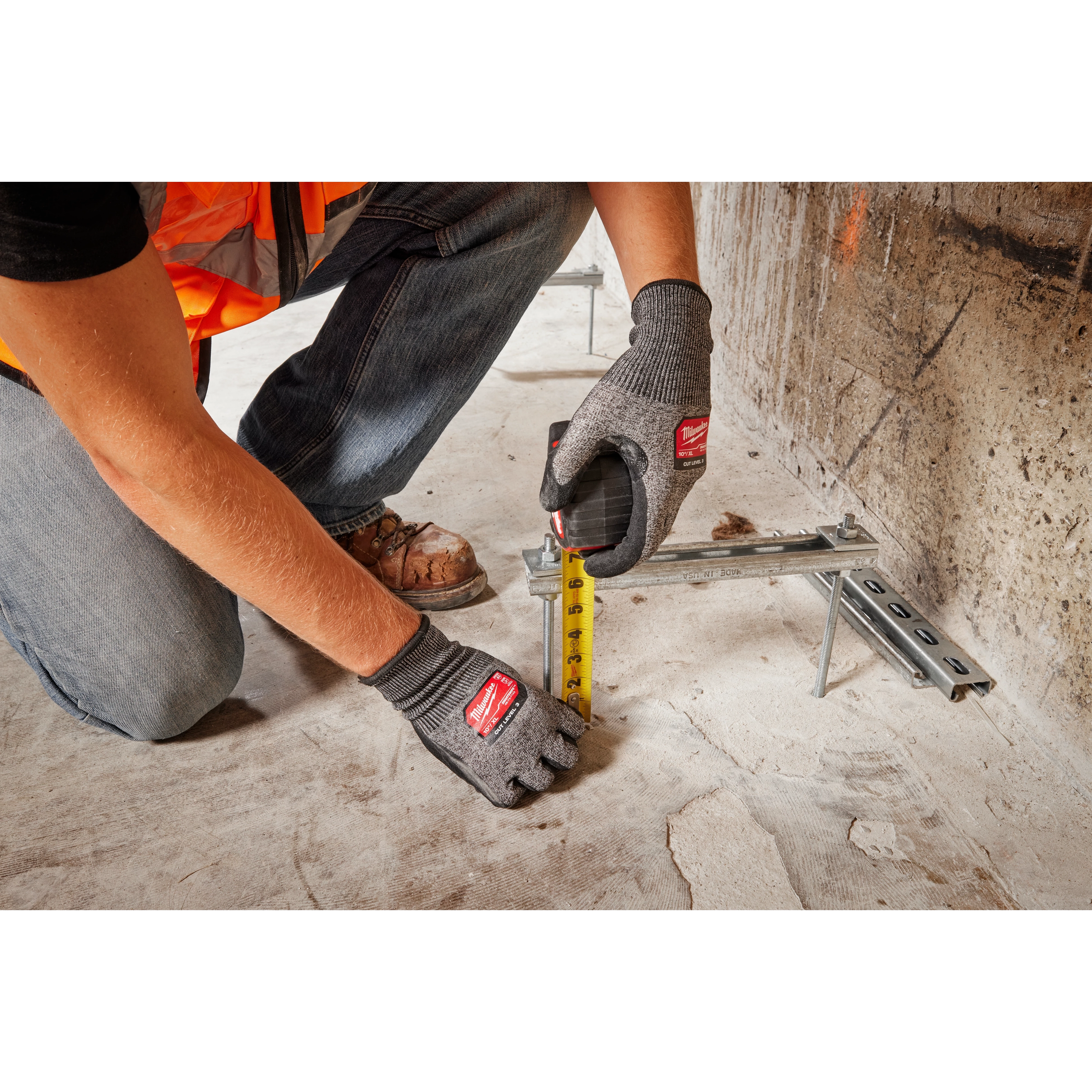 Person wearing Cut Level 3 High-Dexterity Nitrile Dipped Gloves - XL measures with a yellow tape measure on a construction site.