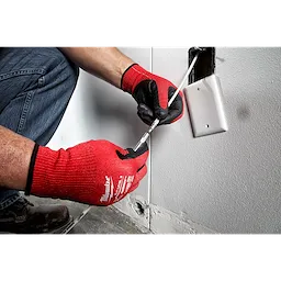 Person wearing red gloves using the 5' High Flex Fish Stick to install wiring through a wall outlet opening.