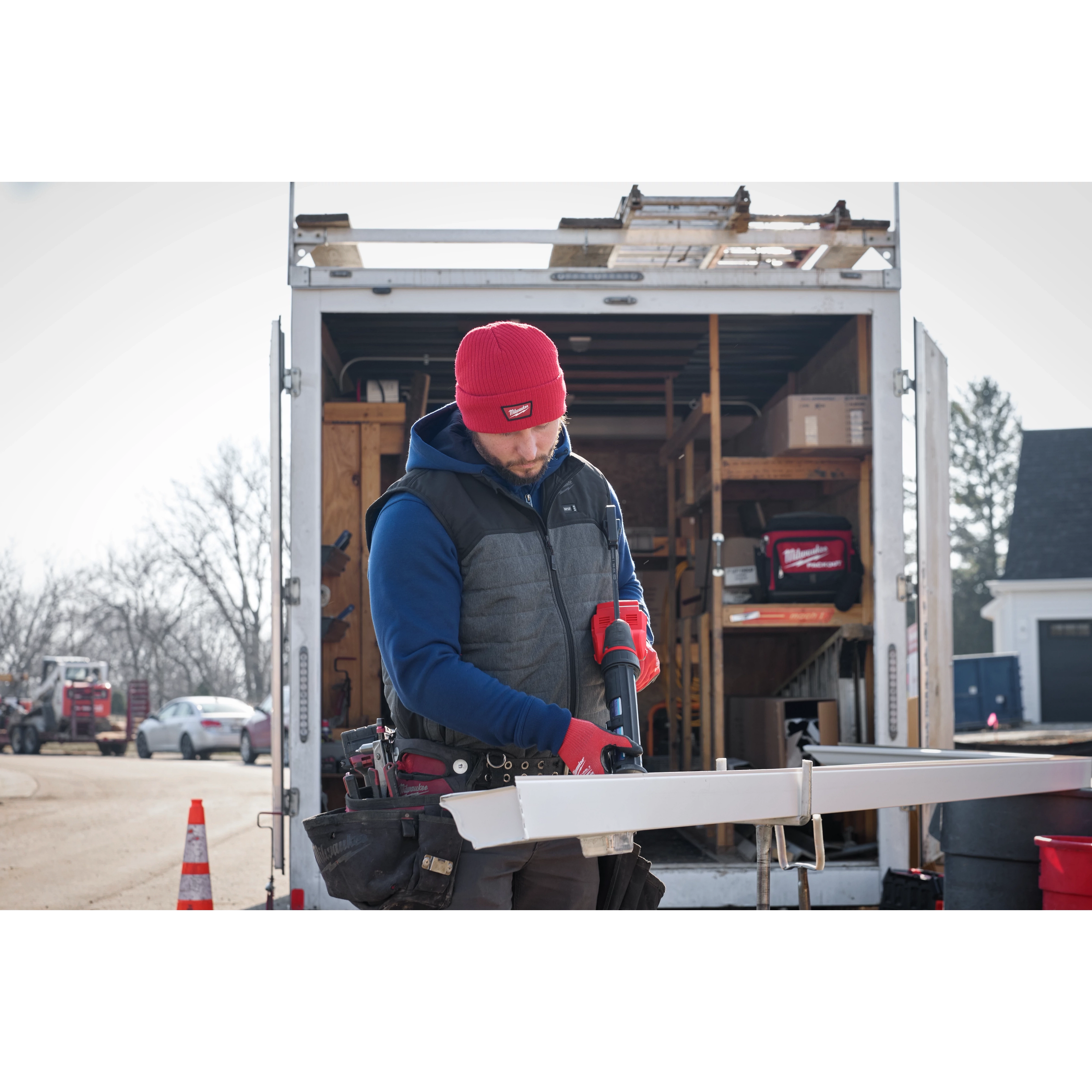 Image of a man on a jobsite wearing the Milwaukee Rib-Knit Cuffed Beanie in red