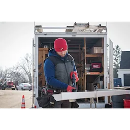 Image of a man on a jobsite wearing the Milwaukee Rib-Knit Cuffed Beanie in red