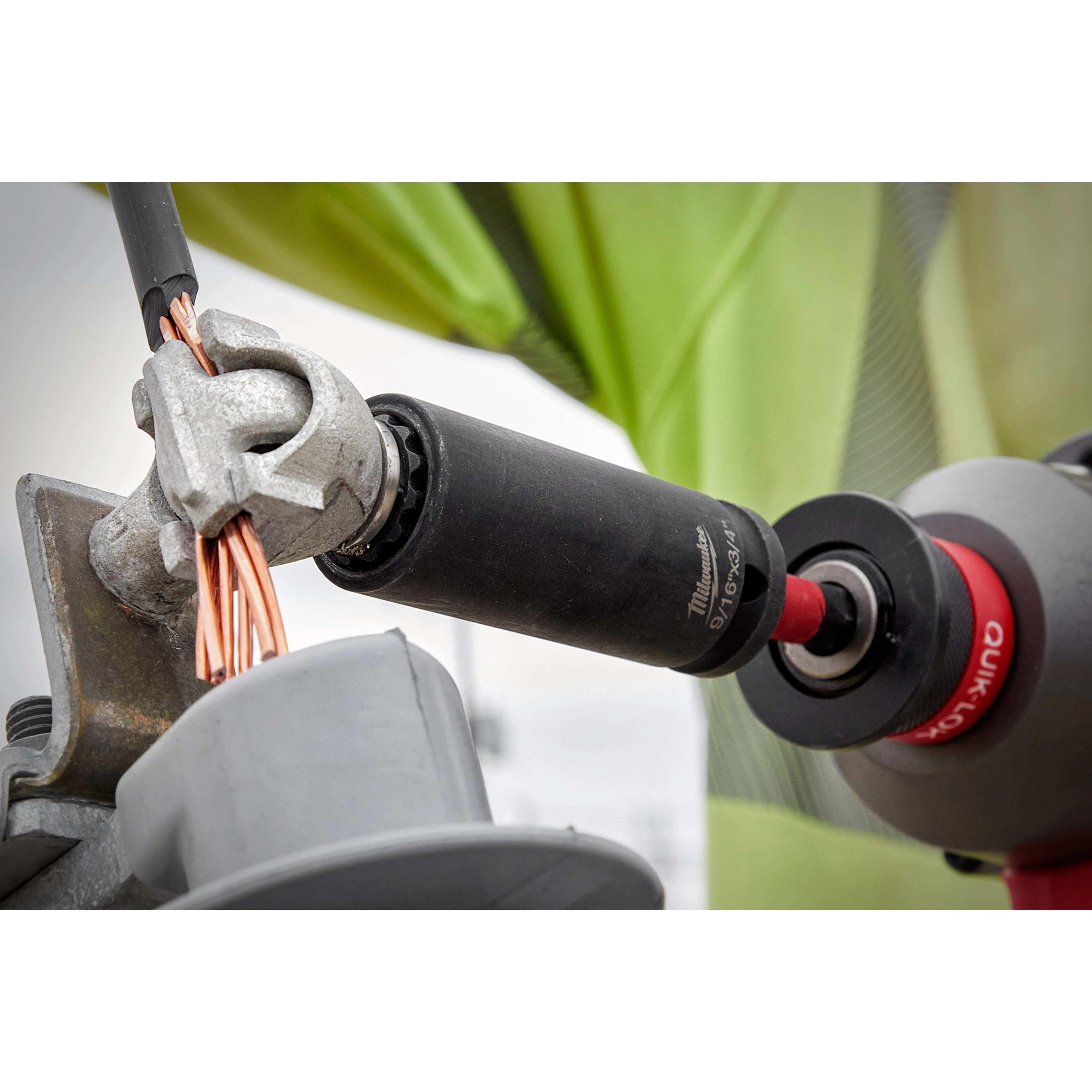 9/16"-3/4" 12PT 2-in-1 Socket being used to tighten a metal connector holding copper wires. Red and black tool handle visible.
