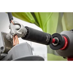 9/16"-3/4" 12PT 2-in-1 Socket being used to tighten a metal connector holding copper wires. Red and black tool handle visible.