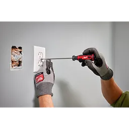 Person using the 3/16" Cabinet 6" Cushion Grip Screwdriver (USA) to install a wall outlet with a partially exposed socket.