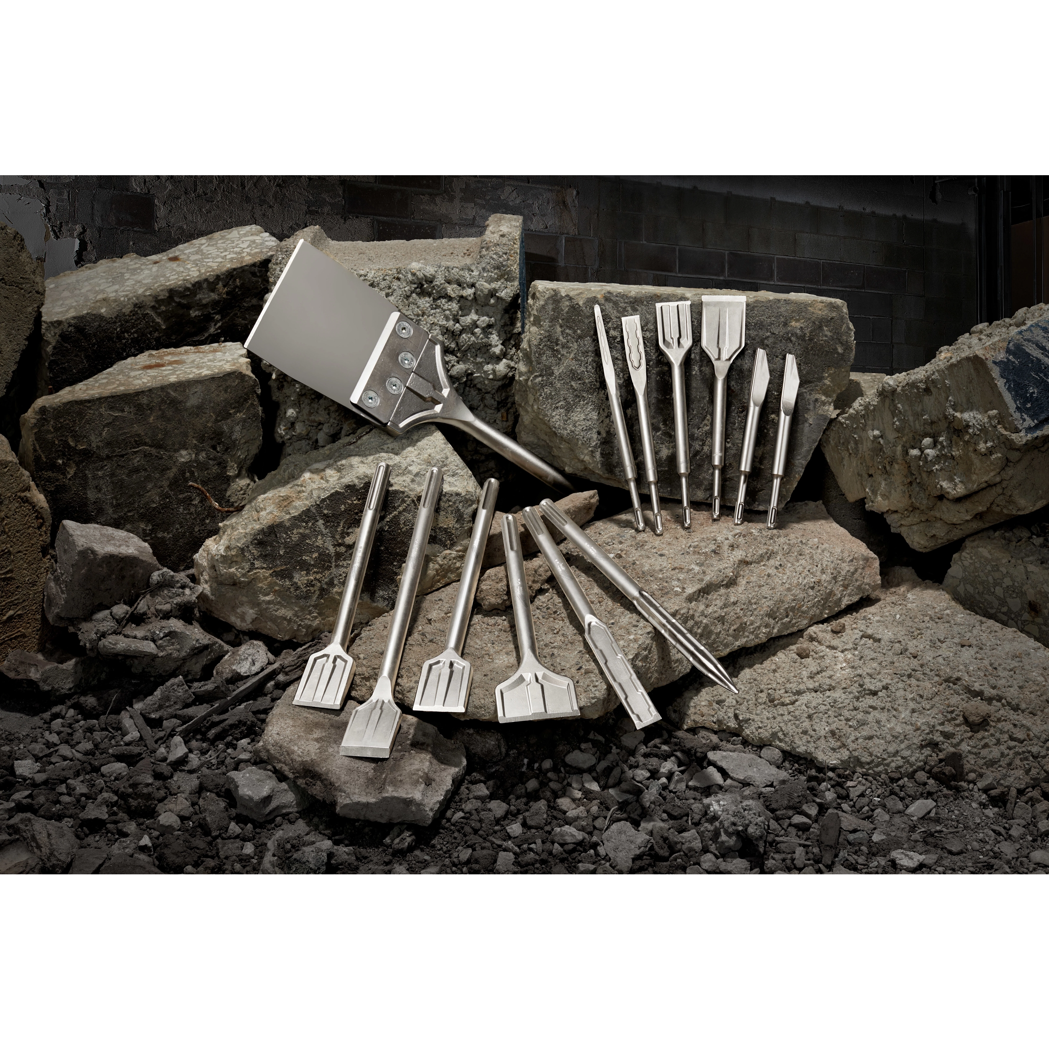 2020 Sledge Chisel Family Shot features various chisels displayed on large rocks, showcasing different shapes and sizes designed for heavy-duty tasks.