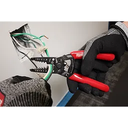 8-20 AWG Dipped Grip Wire Stripper %26 Cutter (USA) used by gloved hands to strip wires from a wall outlet.