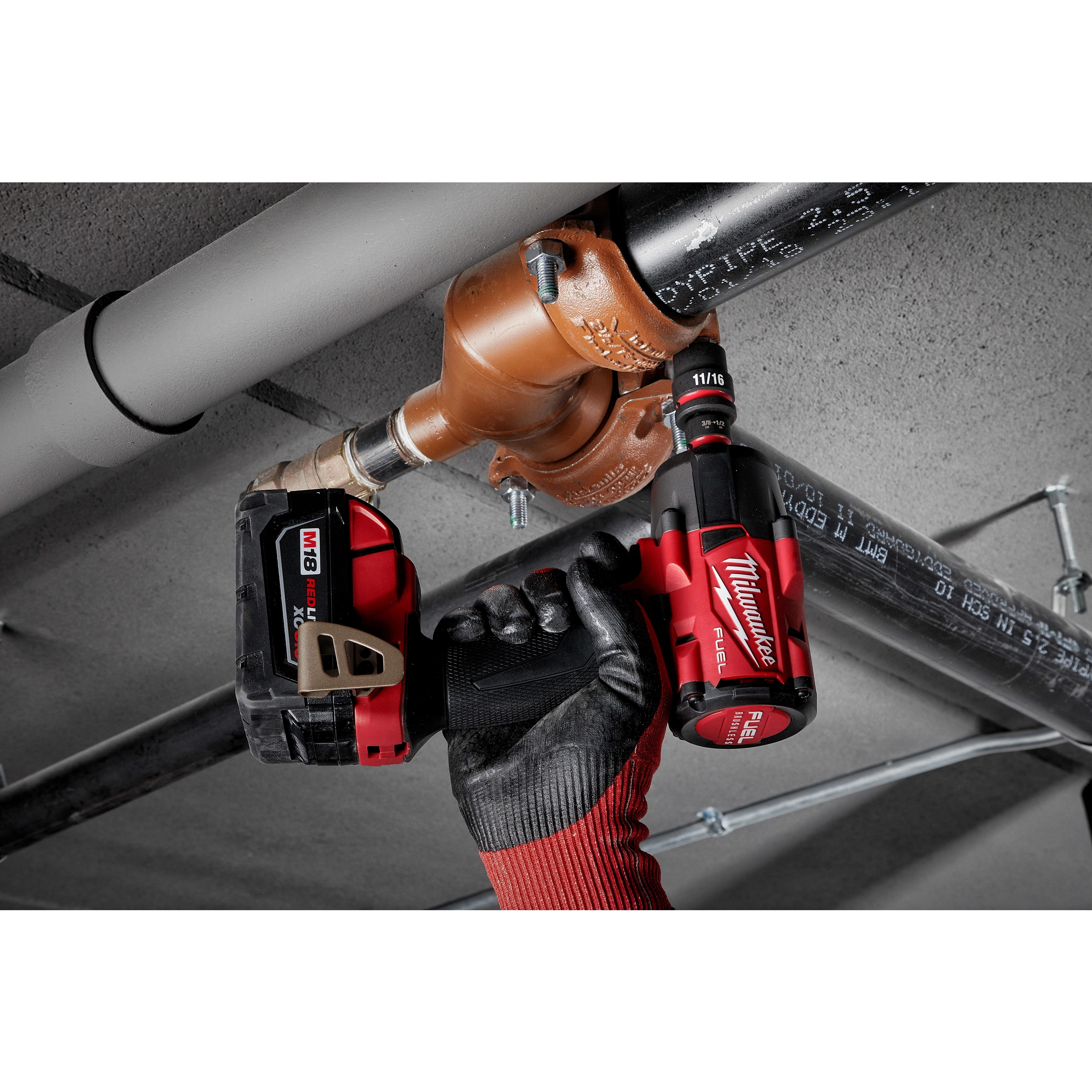 Person using a power tool with SHOCKWAVE Impact Duty 1/2" Drive 11/16" Standard 6 Point Socket to adjust plumbing pipes.