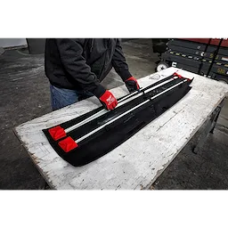 Person assembling a 30%27%20Combo%20Fish%20Stick%20Kit on a table, wearing red gloves. Kit includes several stick rods and a black fabric case.