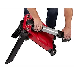Person adjusting the tripod base of an M18 Rocket Light, featuring a red and black design, showing control buttons and grip handles.