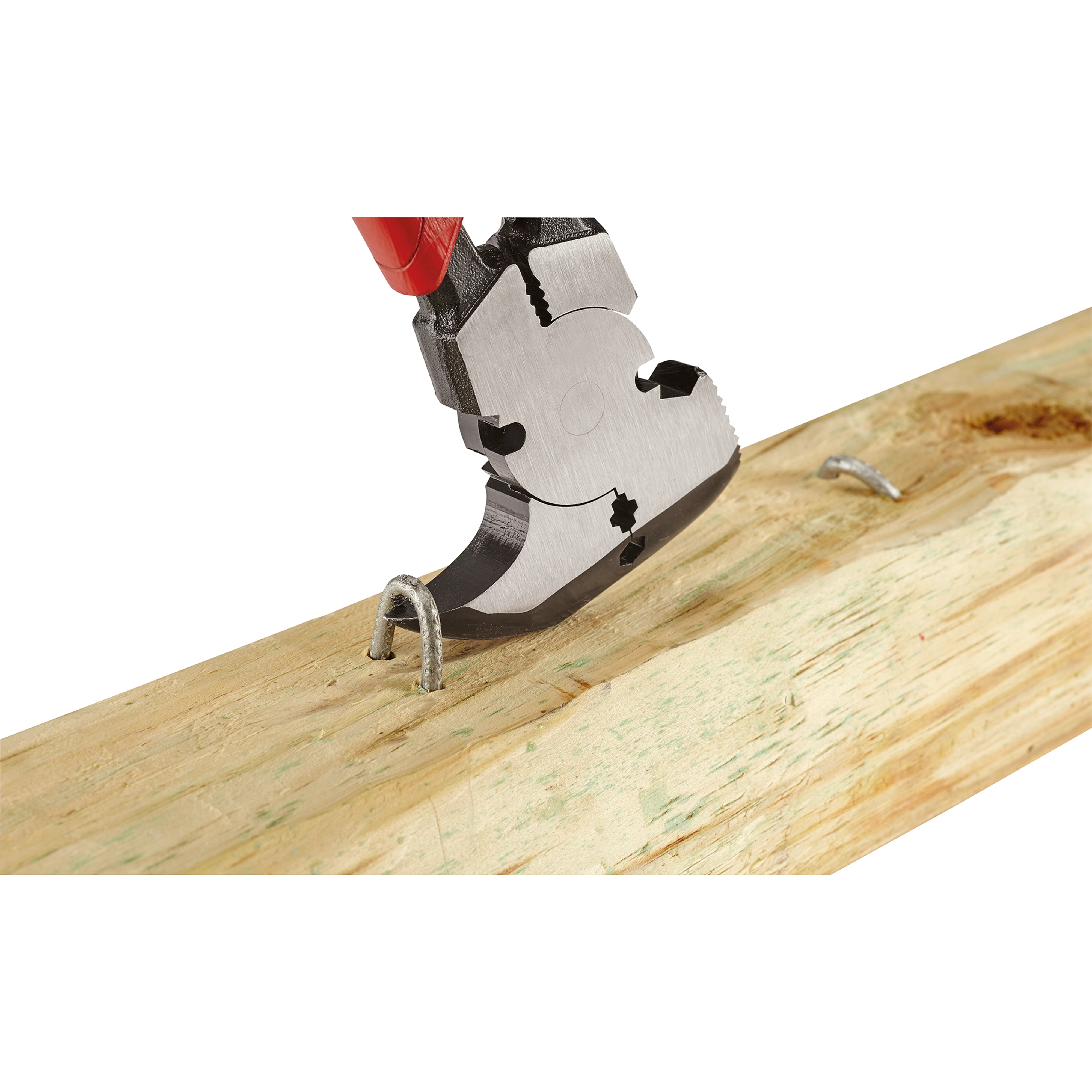 Comfort Grip Fencing Pliers are being used to remove a metal staple from a wooden board. The pliers have a red handle and a multi-functional head designed for gripping and cutting various wire types.
