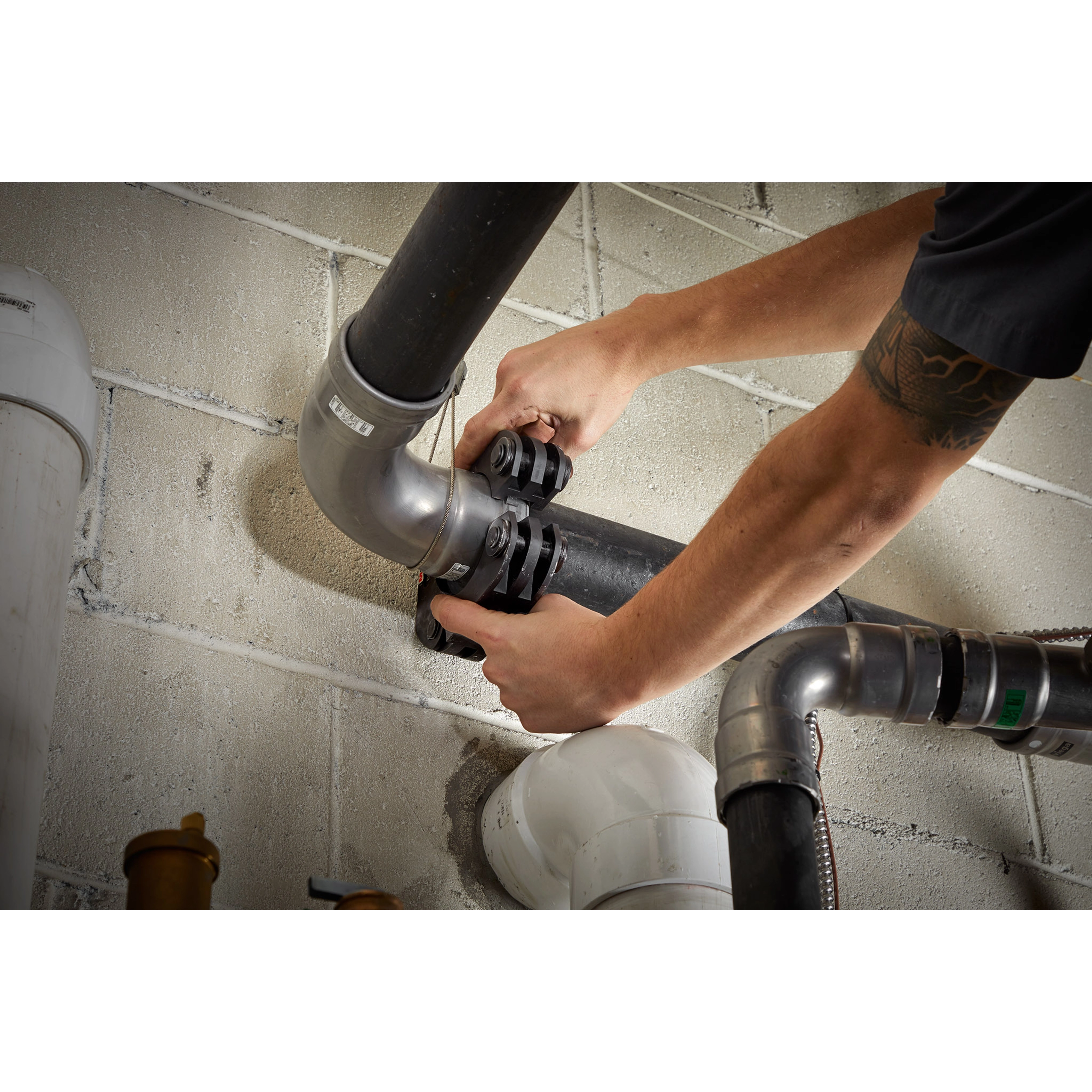 Person using the 2 ½” - 4” IPS XL Ring Kit for M18 FORCE LOGIC Long Throw Press Tool to secure a black pipe.