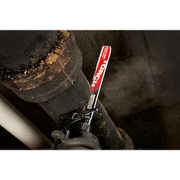 Milwaukee 9” CAST IRON, TORCH w. Nitrus Carbide Sawzall Blade cutting through a rusted, black iron pipe with sparks and dust.