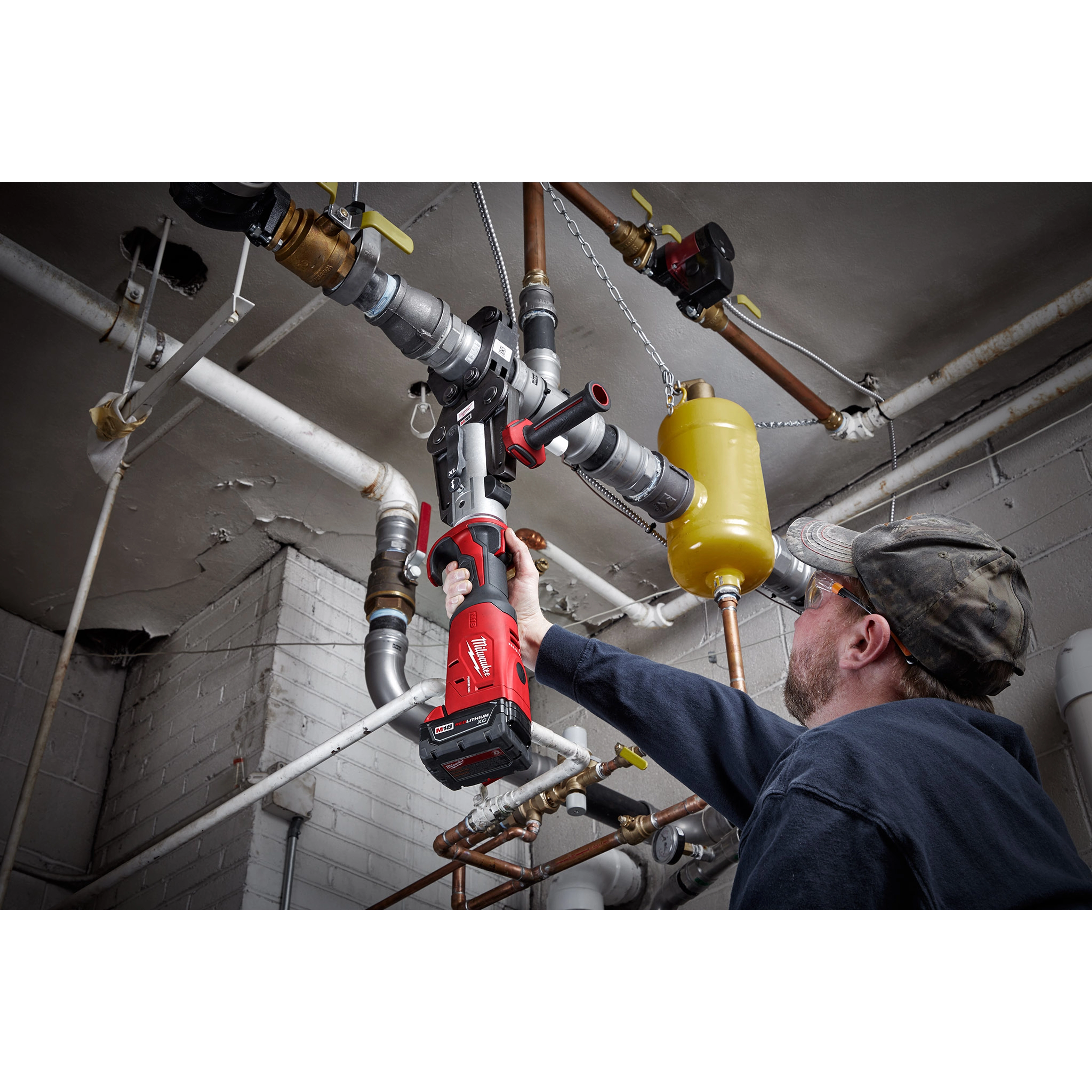 Worker using 2 ½”- 4” IPS XL Ring Kit for M18 FORCE LOGIC Long Throw Press Tool to connect large industrial pipes.