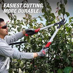 Person trimming leafy branches with a 1-1/2” Lopper​ featuring long handles and cushioned grips.